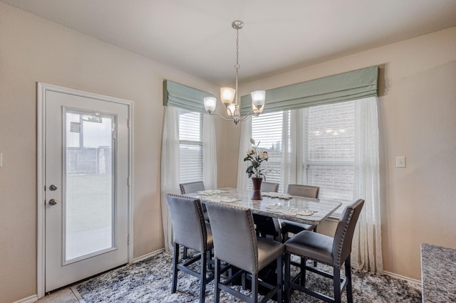 dining room featuring baseboards and a chandelier