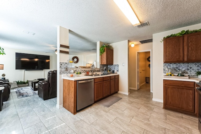 kitchen with visible vents, a ceiling fan, open floor plan, light countertops, and stainless steel dishwasher