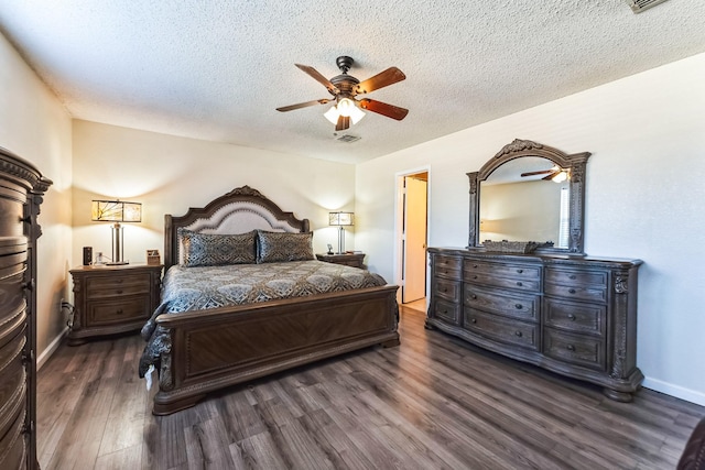 bedroom with baseboards, visible vents, a ceiling fan, dark wood-type flooring, and a textured ceiling