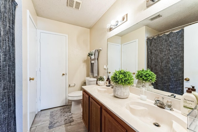 full bathroom featuring visible vents, a sink, a textured ceiling, and toilet