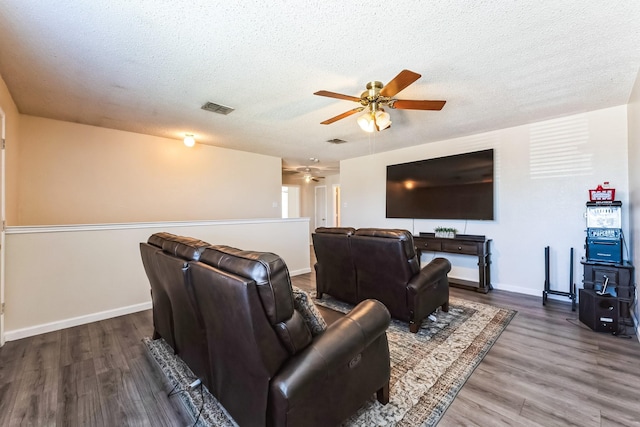 interior space with baseboards, a textured ceiling, visible vents, and wood finished floors