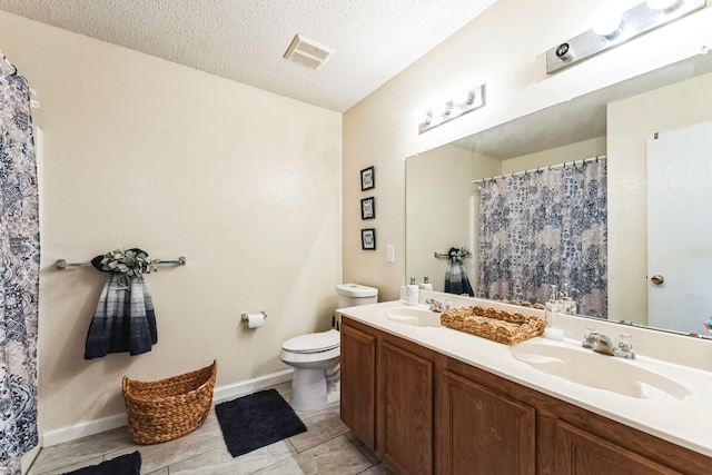 bathroom featuring visible vents, a sink, a textured ceiling, and toilet