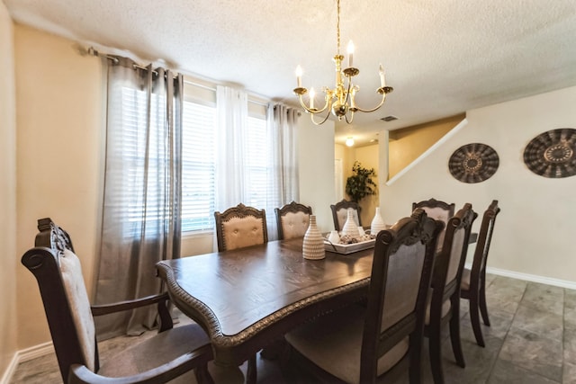 dining space with an inviting chandelier, baseboards, visible vents, and a textured ceiling