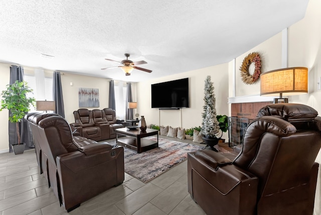 living room featuring a textured ceiling, plenty of natural light, a fireplace, and visible vents