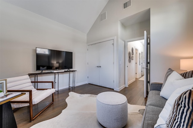 bedroom with high vaulted ceiling, wood finished floors, visible vents, and baseboards