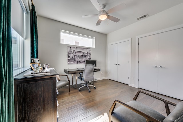 office with wood-type flooring, visible vents, and a ceiling fan