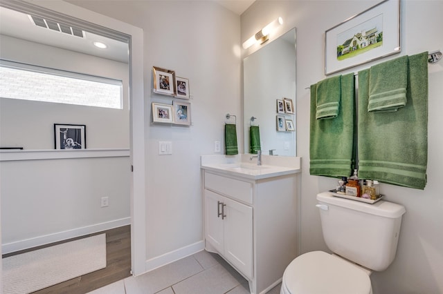 bathroom with tile patterned floors, vanity, toilet, and baseboards