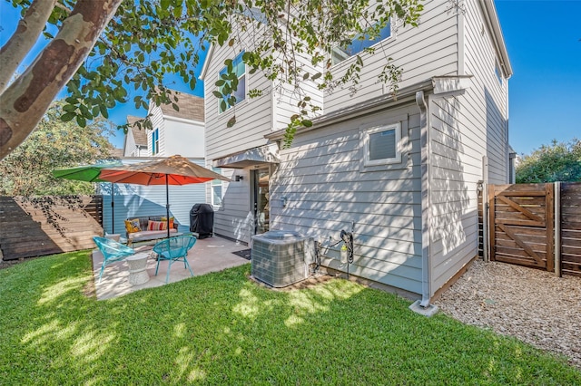 back of property with central air condition unit, fence, a lawn, and a patio