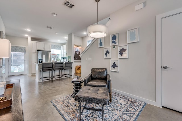 sitting room with recessed lighting, visible vents, concrete floors, and baseboards