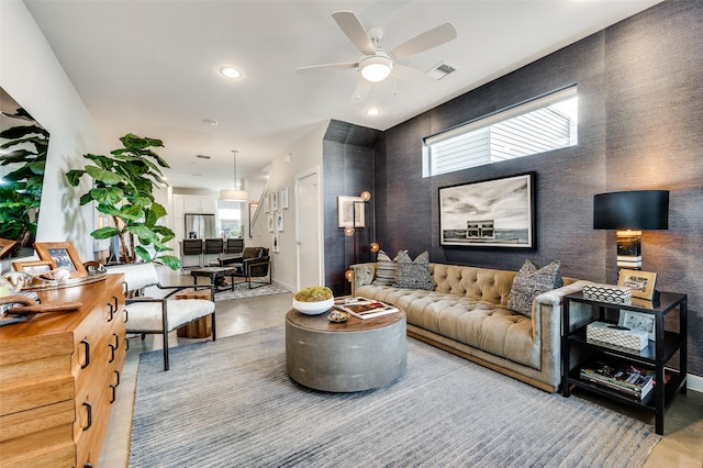 living room with recessed lighting, an accent wall, a ceiling fan, baseboards, and visible vents