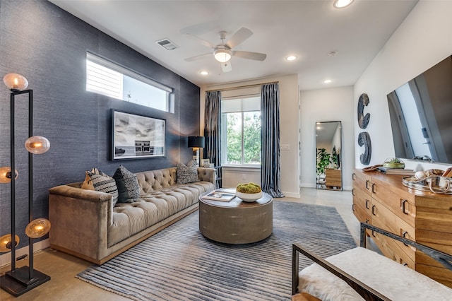 living area with baseboards, an accent wall, visible vents, and recessed lighting