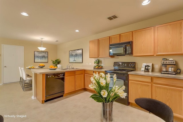 kitchen with a peninsula, a sink, visible vents, light countertops, and black appliances