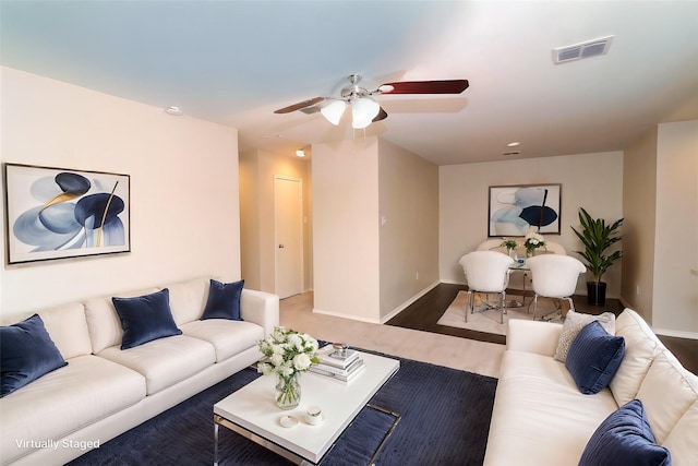 living room with a ceiling fan, wood finished floors, visible vents, and baseboards