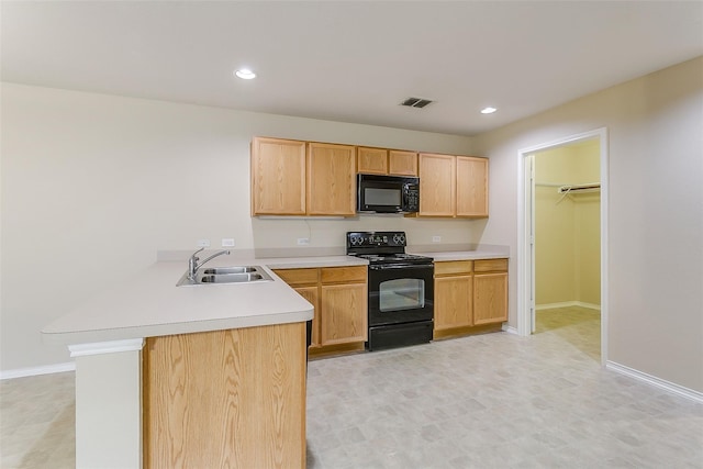 kitchen with visible vents, a peninsula, light countertops, black appliances, and a sink