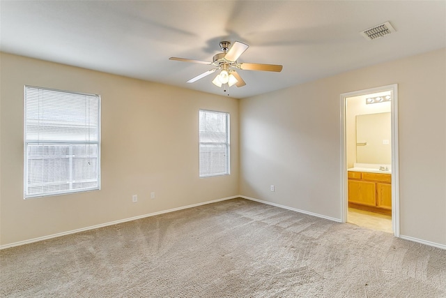 empty room with light carpet, ceiling fan, visible vents, and baseboards