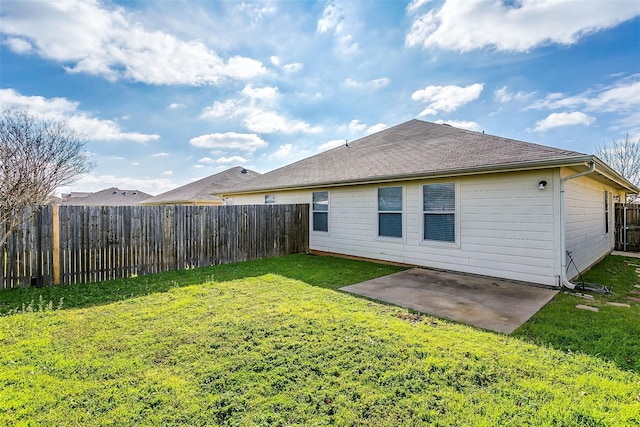 rear view of property with a patio, a shingled roof, a lawn, and a fenced backyard