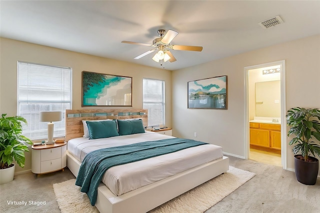 bedroom featuring light colored carpet, connected bathroom, visible vents, and baseboards