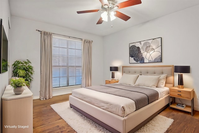 bedroom with ceiling fan, baseboards, and wood finished floors