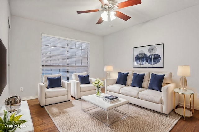 living room featuring wood finished floors, a ceiling fan, and baseboards