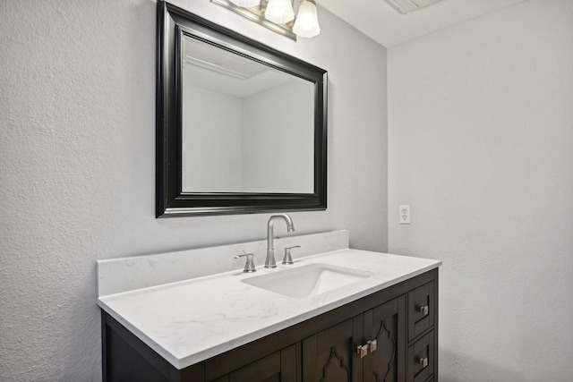 bathroom featuring a textured wall and vanity