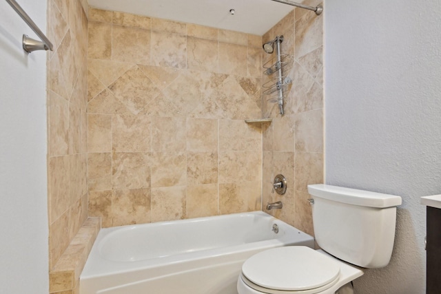 bathroom with a textured wall, shower / bathing tub combination, vanity, and toilet