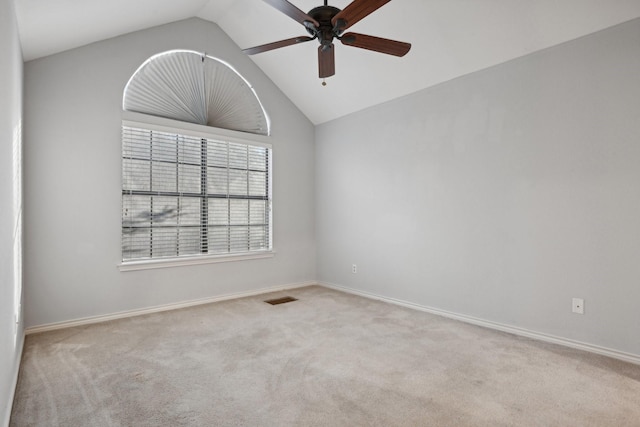 spare room with carpet, visible vents, vaulted ceiling, and baseboards