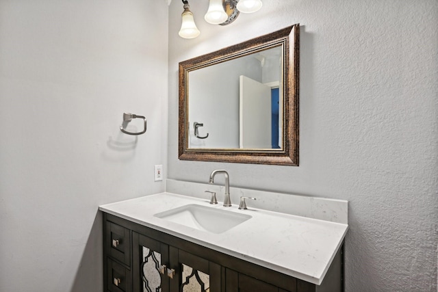 bathroom with a textured wall and vanity