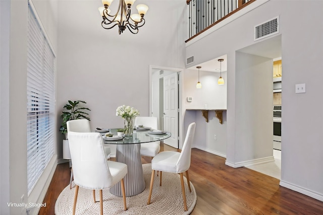 dining room with visible vents, a chandelier, and wood finished floors