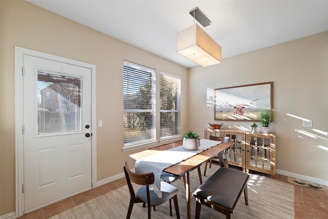 dining space featuring light tile patterned flooring and baseboards