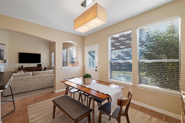 dining area featuring light tile patterned floors, a wealth of natural light, and baseboards