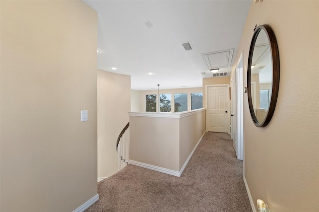 corridor featuring visible vents, carpet flooring, and an upstairs landing