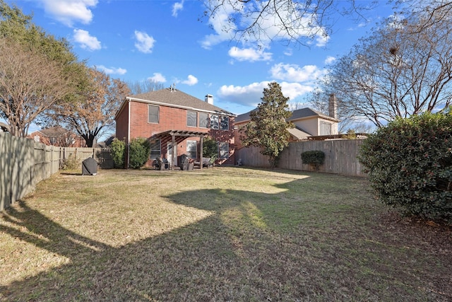 back of property with brick siding, a yard, a fenced backyard, and a pergola