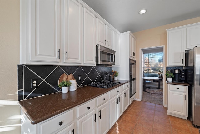 kitchen with black appliances, light tile patterned floors, and white cabinetry