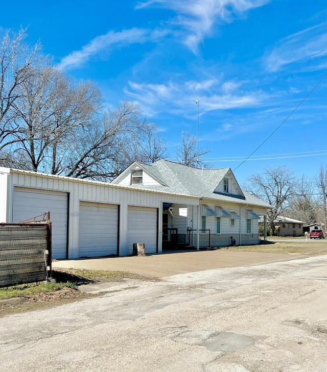 view of front facade featuring a garage and a shingled roof