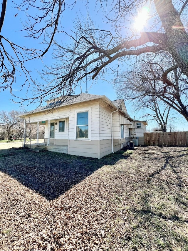 view of side of property featuring fence and central AC