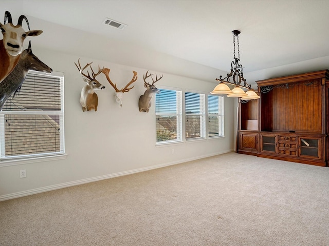 empty room with carpet floors, baseboards, and visible vents