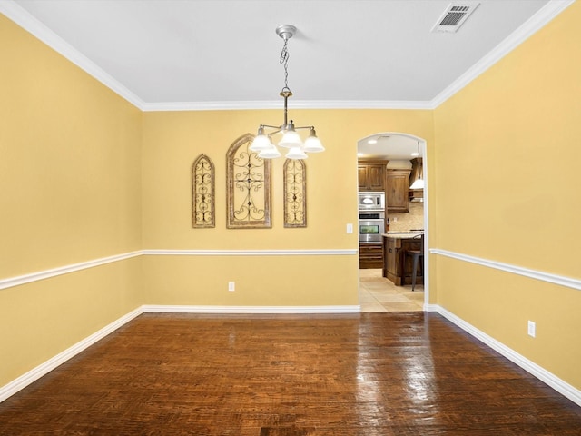 unfurnished dining area featuring light wood finished floors, baseboards, visible vents, and arched walkways