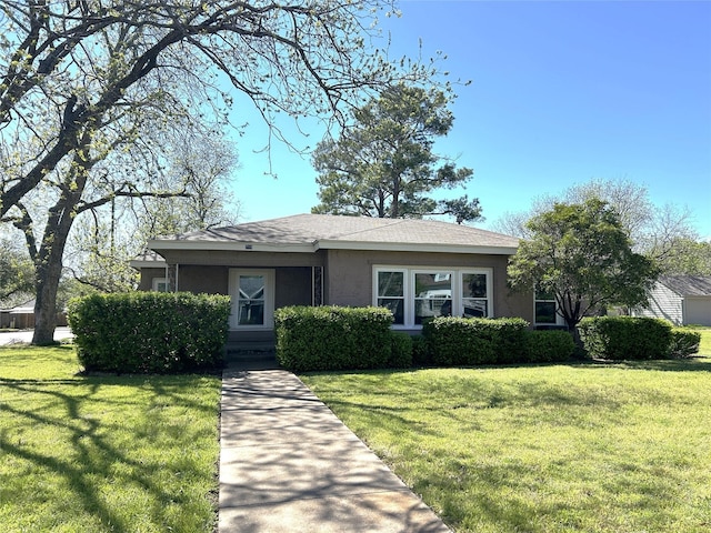 view of front of home with a front yard and stucco siding