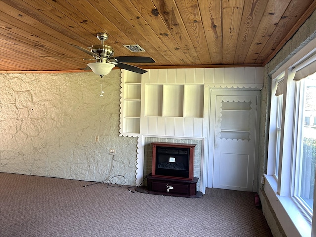 unfurnished living room featuring a fireplace, visible vents, a ceiling fan, carpet flooring, and wooden ceiling