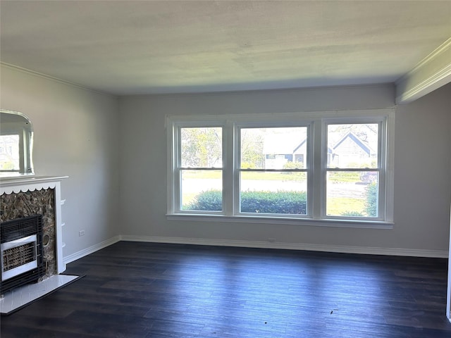 unfurnished living room with dark wood-style flooring, crown molding, heating unit, a high end fireplace, and baseboards