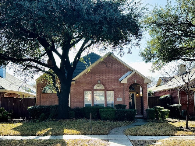 view of front of house with brick siding and fence