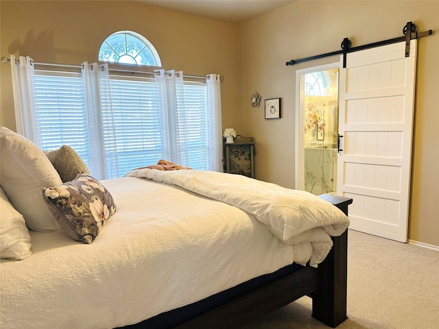 carpeted bedroom featuring ensuite bathroom and a barn door