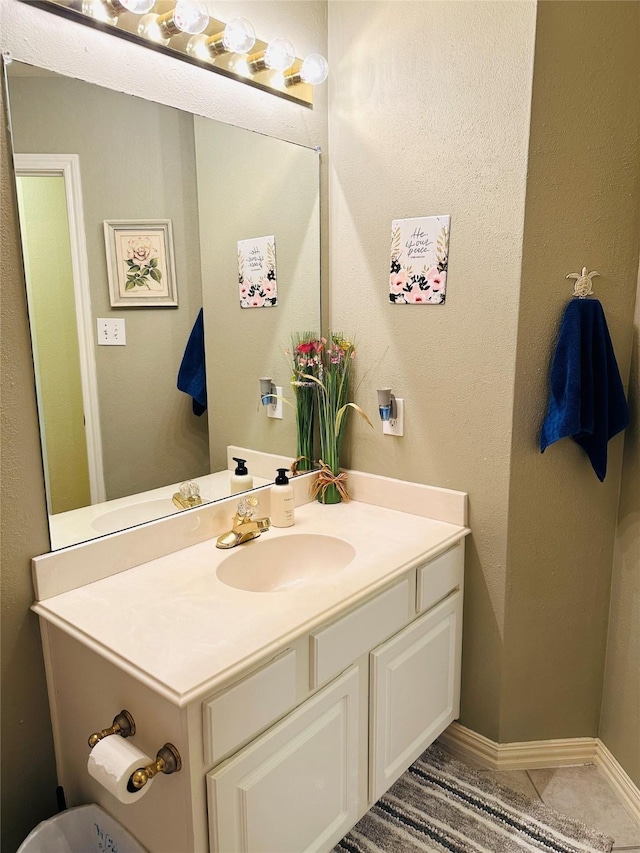 bathroom featuring tile patterned flooring, baseboards, and vanity