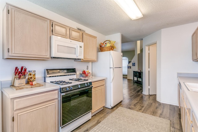 kitchen featuring light wood-type flooring, white appliances, light countertops, and light brown cabinetry