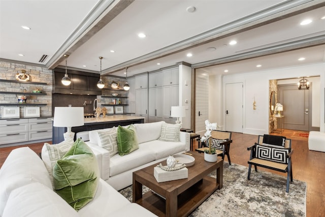 living room featuring recessed lighting, wood finished floors, visible vents, ornamental molding, and wet bar