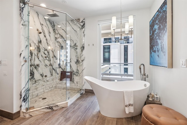 2300 Wolf St Unit 3D, Dallas, TX 75201 - full bath with a marble finish shower, baseboards, wood tiled floor, a freestanding tub, and a chandelier