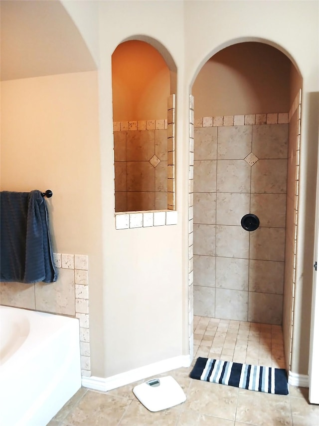 full bath with baseboards, tiled shower, a garden tub, and tile patterned flooring