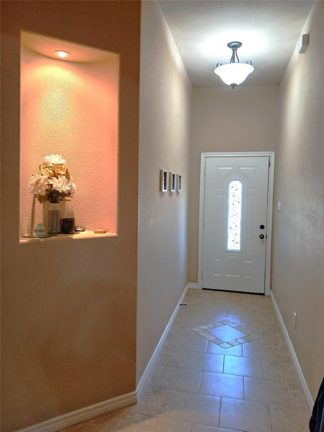 entryway featuring light tile patterned flooring and baseboards