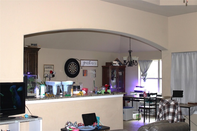 kitchen with arched walkways, an inviting chandelier, and a peninsula