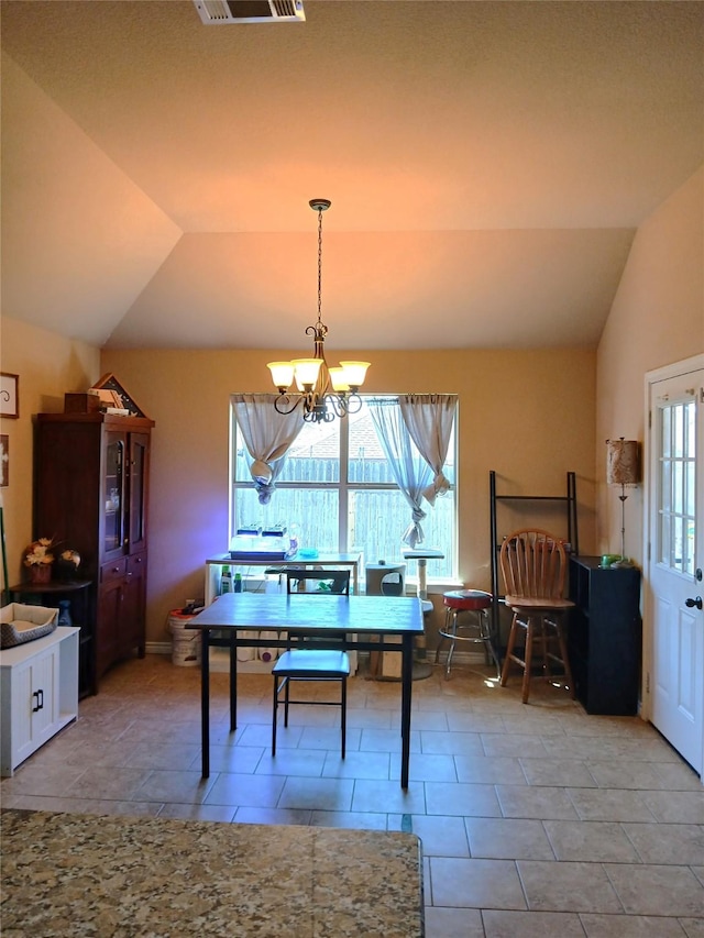 dining space with tile patterned flooring, lofted ceiling, a notable chandelier, and visible vents